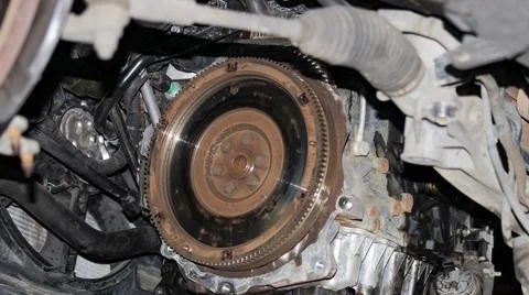 Close-up of car flywheel inside engine bay with visible rust and heat marks.. Fotos Stock