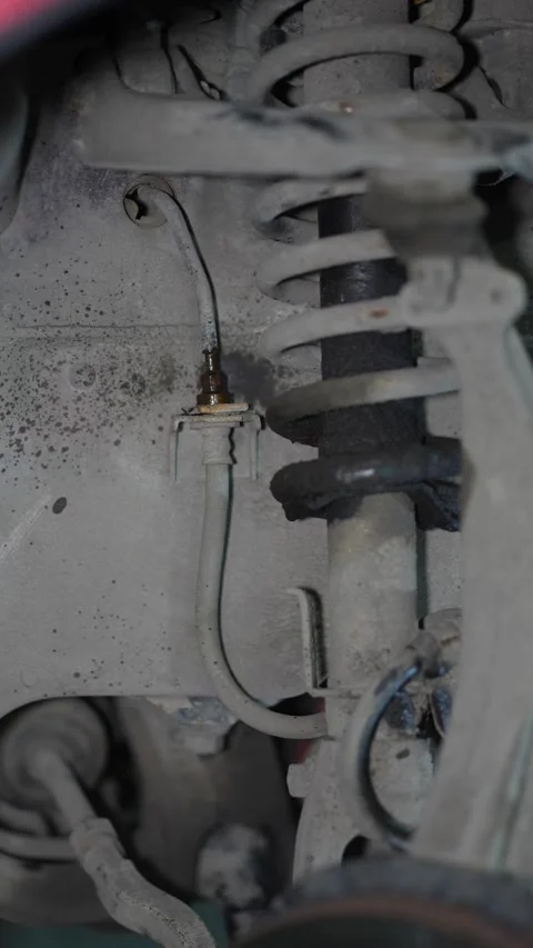 Close-up of a car front suspension strut and brake hose. Stock Footage 345708226