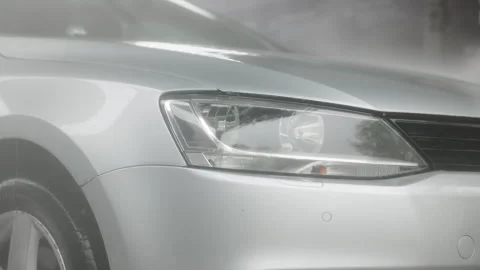 Close-up of car headlight being washed with water and foam, silver vehicle Stock-Footage 319699633