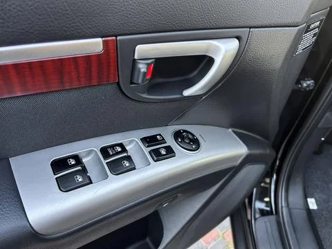 Close-up of a car interior door panel highlights the window controls and lock 库存照片