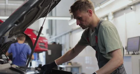 Close up of car mechanic removes the engine cover of a car Stock Footage 341862948