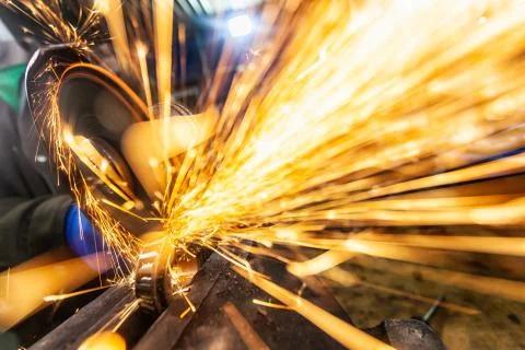 A close-up of a car mechanic using a metal grinder to cut   bearing in an aut Stock Photos