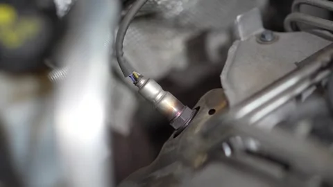 Close-up of a car oxygen sensor installed in exhaust manifold. Stock Footage 345709238
