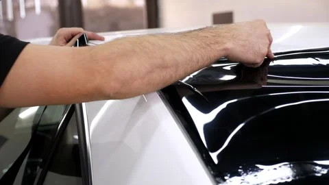A close-up of the car servicemaster glues the tinting film on the glass. Stock Footage 312436205