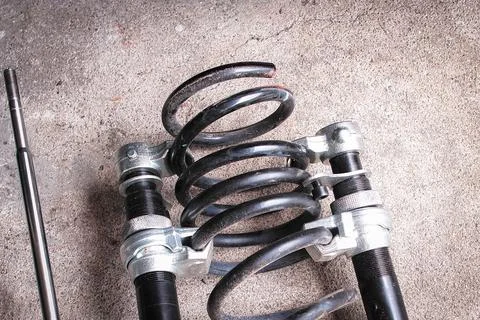 Close-up of car shock spring being removed with spring removal tool Foto stock