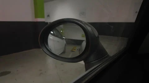 Close-up of a car side mirror beside a white car parked in a garage, Cote Stock Footage 344827692