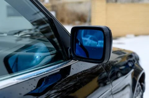 Close-up of car side mirror reflecting snowy landscape and vehicle Stock Photos