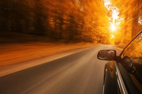 Close up of a car speeding on the empty, autum road Stock Photos