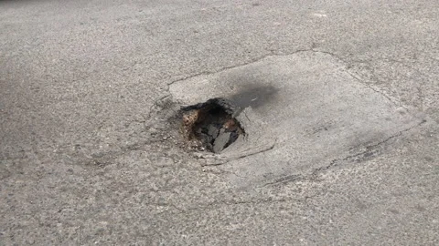 Close-up of a car stepping on a gap in the road. Video stock 149387999