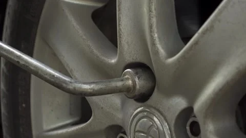Close up of a car wheel lug nut being loosened and removed Stock Footage 332270708