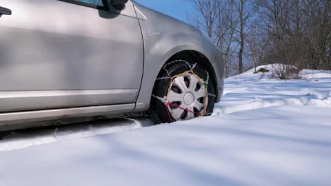 Close-up of a car wheel with snow chains installed for winter driving. The Stock Footage 303511526