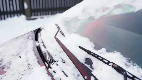 Close-up of car windshield covered in fresh snow as wiper clears the glass Video stock 327521176