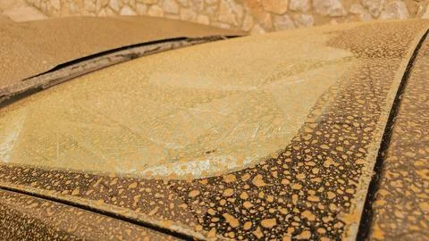 Close up of car windshield covered in orange African Saharan dust dried rai.. Stock Photos