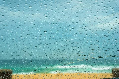 Close up of car windshield with raindrops and sandy beach Stock Photos