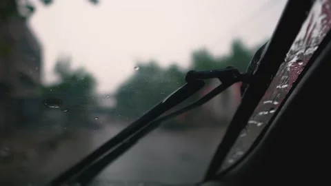 Close of a car windshield wiping rain drops water splash Stock Footage 138734982