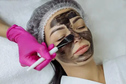 Close-up of carbon peeling procedure for middle-aged woman face. Laser pulses Stock Photos