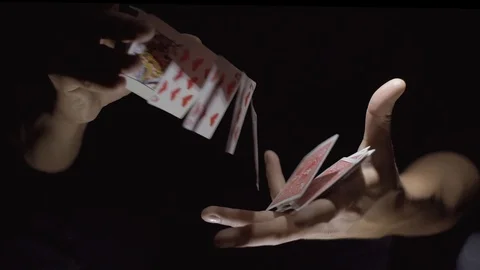 Close-up. Cards fly from one hand to another. The magician shows a card trick Video stock 89581541
