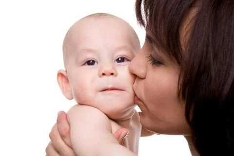 Close-up of careful mummy kissing her baby son on white background Stock Photos