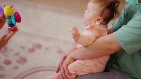 Close up of a caregiver lifting and supporting an infant during mobility Stock Footage 336926537