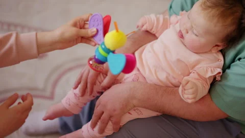 Close up of a caregiver lifting and supporting an infant during mobility Видео 336926730