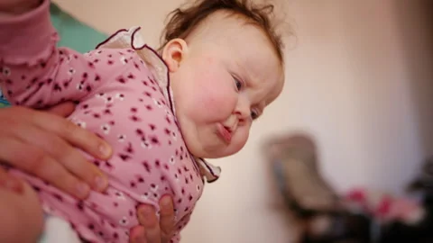 Close up of a caregiver lifting and supporting an infant during mobility Stock Footage 336934053