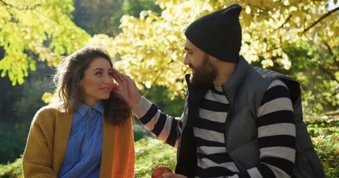 Close up of caressing romantic couple sitting in the park on a sunny day in the Stock Footage 82514831
