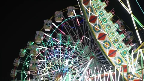 Close up of carnival lights, ferris wheel, giant rides in an amusement park 스톡 동영상 70669702