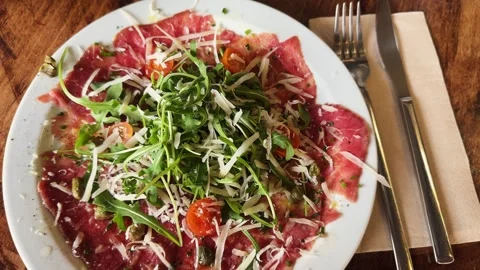 Close up of carpaccio with arugula, cheese, cherry tomatoes and capers. Stock Footage 306603032