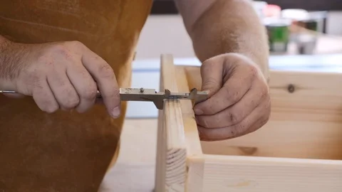 Close-up. A carpenter with a caliper makes measurements. A man works with a tree Stock Footage 113996389