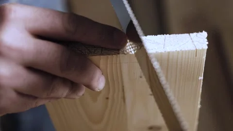 Close up. carpenter cuts out a dovetail on a wood board with a hand saw. mast Stock Footage 166341003
