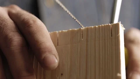 Close-up. carpenter cuts out a dovetail on a wood board with a hand saw. Stock Footage 166341005