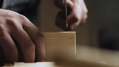 Close up. a carpenter cuts out a dovetail on a wooden board with a hand saw.  Stock Footage 166341054
