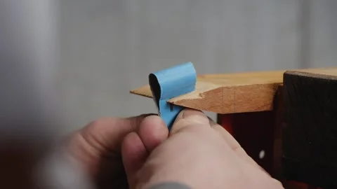 Close-up. carpenter grinds teeth on a wooden comb with sanding paper Stock Footage 156670123