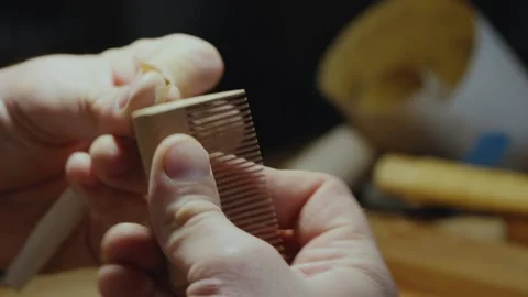 Close-up. a carpenter grinds a wood comb with sanding paper Stock Footage 156670258