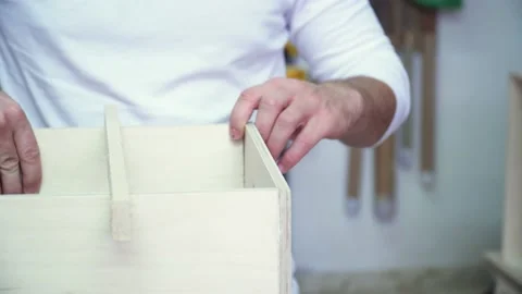 Close up on carpenter hands assembling planks of timber wood to make a Stock Footage 220759074