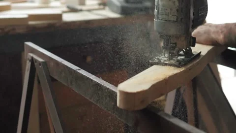 Close-up, a carpenter in his workshop saws a wooden board with an electric Stock Footage 196515693