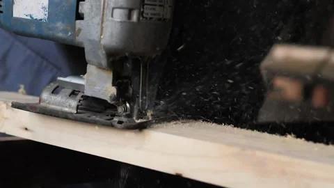 Close-up, a carpenter in his workshop saws a wooden board with an electric Stock Footage 196515865