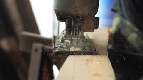 Close-up, a carpenter in his workshop saws a wooden board with an electric Stock Footage 196516177