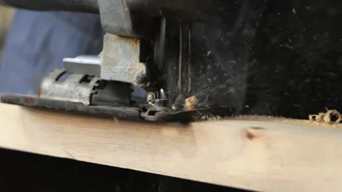 Close-up, a carpenter in his workshop saws with an electric jigsaw, makes Stock Footage 196516212