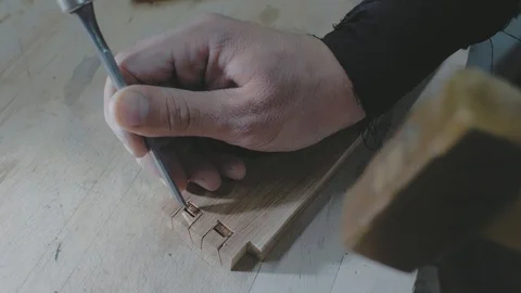Close-up, carpenter making a dovetail on a wooden part with a chisel and hammer Stock Footage 116528846