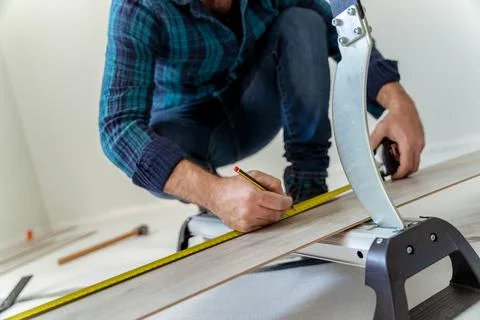 Close up carpenter man cutting a sheet of wood to install a wooden floor Stock Photos