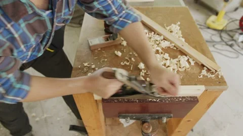 Close up carpenter planning to smooth the face of wood Stock Footage 173694402