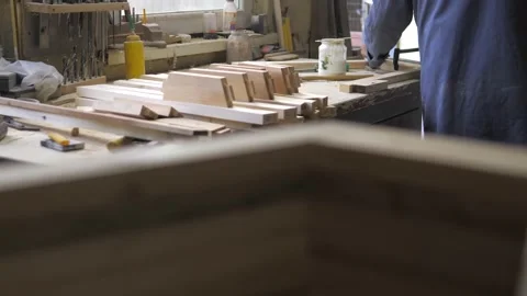 Close-up of a carpenter tightening two screw clamps to a piece of light wood.A Stock Footage 201301218
