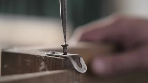 Close-up.the carpenter unscrews the screw with a screwdriver from a wooden board Stock Footage 155860956