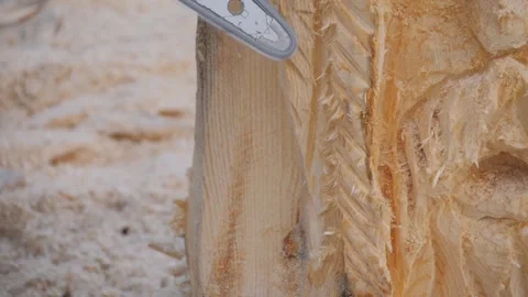 Close up: carpenter using chainsaw for carving wooden sculpture - slow motion Stock Footage 331654761