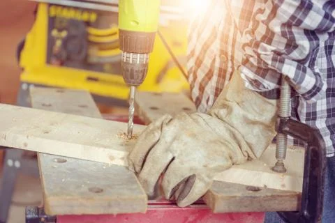 Close up of The carpenter is using drill to mae hole in wooden plank 写真素材