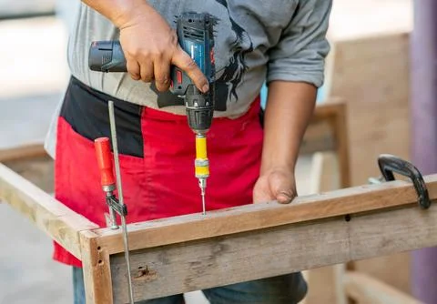 Close-up of a carpenter using an electric cordless drill screwdriver to dri.. Fotos de archivo