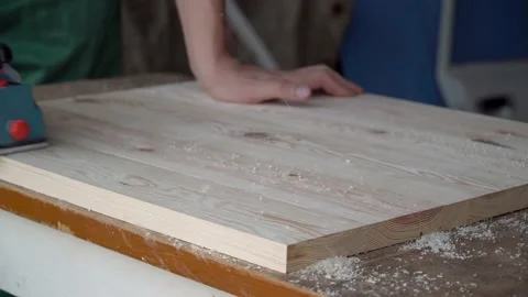 Close up carpenter working with electric planer on wooden plank in workshop. Cra Video stock 228999852