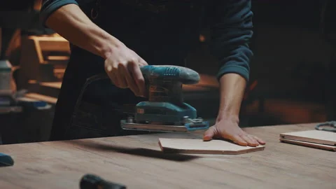 Close up of a carpenters hands with a grinder. A young apprentice guy works in a 스톡 동영상 170667291