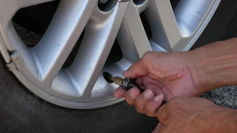 Close up to car's tire while driver inflating car tire in sunny daytime. Ha.. Stock Footage 286312100